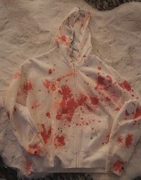 a white hoodie with blood splattered on it